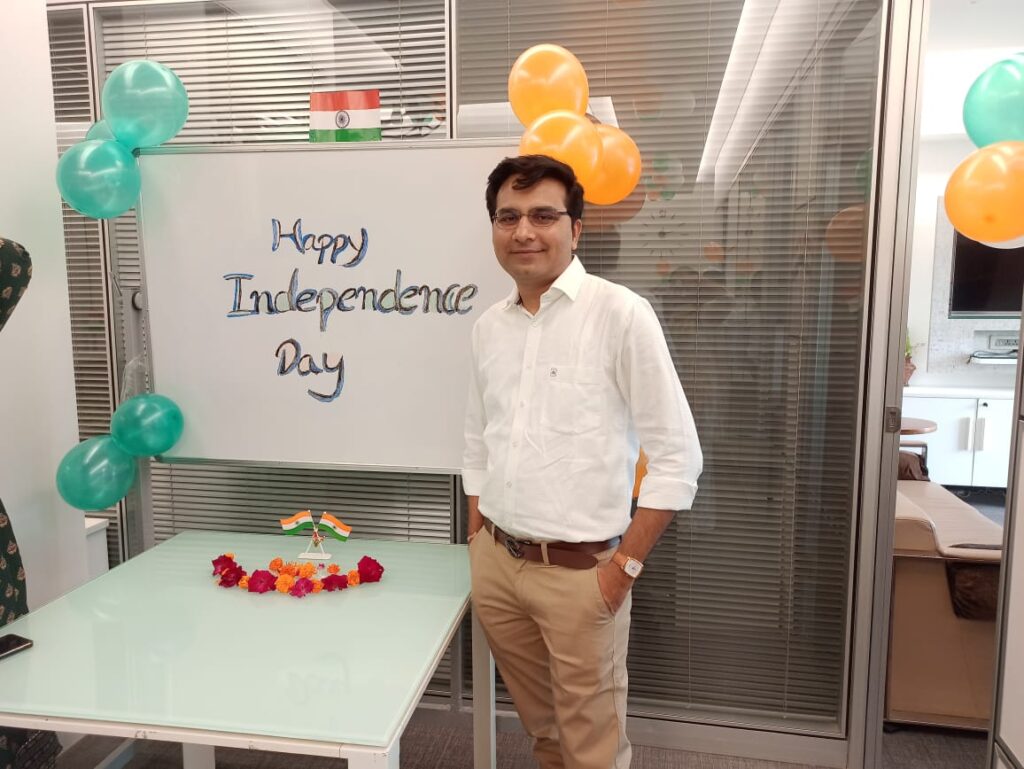 This image shows a ProCARE team member in ProCARE's office standing next to a whiteboard with the words Happy Independence Day on it. 