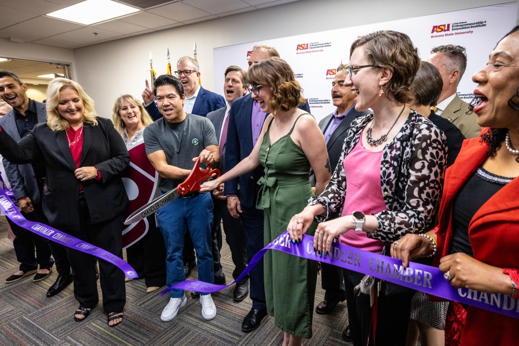 A ribbon-cutting ceremony for the re-opening of ASU's Chandler Innovations Center. ProCARE's CEO & Founder, Jack Liu, is featured in the middle of the photo, cutting the purple ceremonial ribbon with a large pair of scissors.